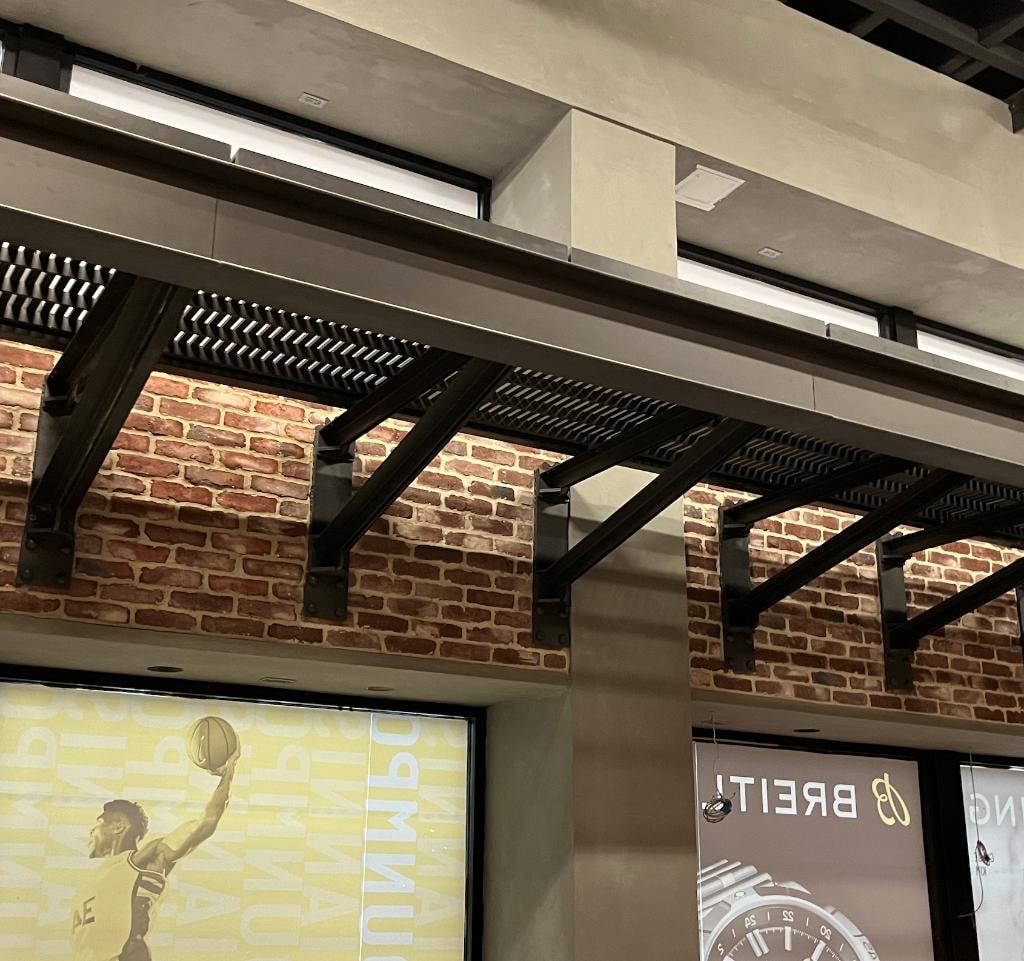 Decorative catwalk with black steel support brackets against exposed brick