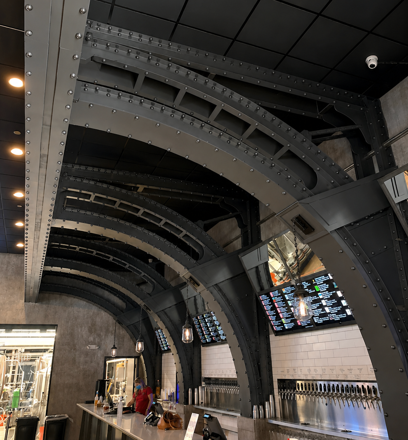 Decorative riveted steel arched buttresses over a bar interior