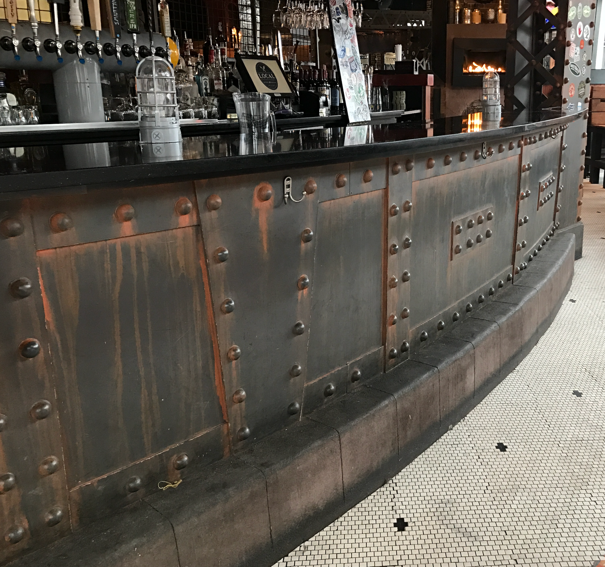 Rusted bar wrap with riveted steel panels and copper accents