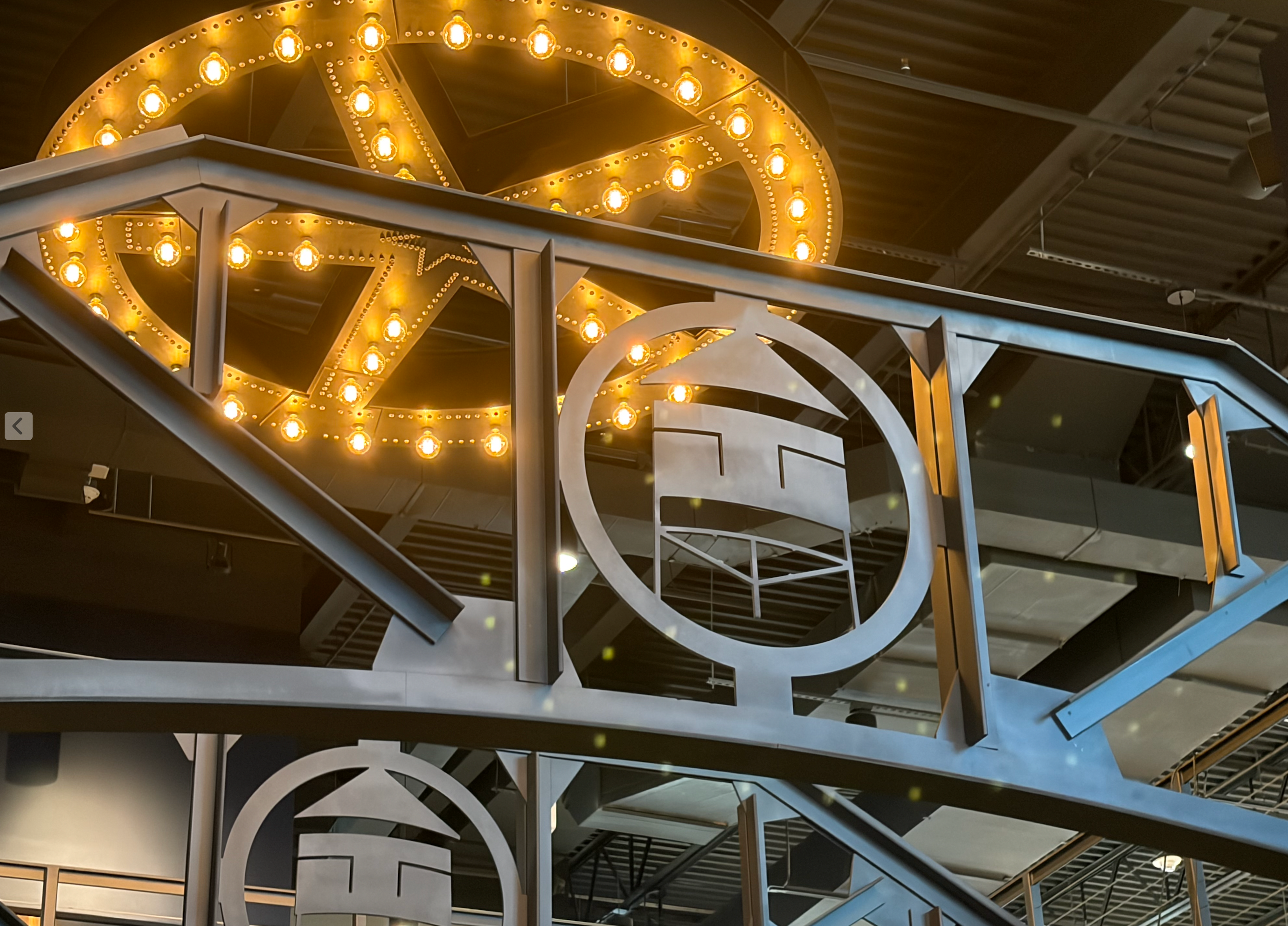 Illuminated vintage marquee signage with industrial steel trusses